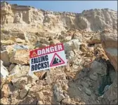  ?? K.C. Alfred San Diego Union-Tribune ?? A WARNING SIGN on the oceanfront bluffs near 9th Street in Del Mar. The bluffs were formed by tectonic shifts and landslides over the centuries.