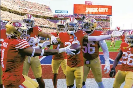  ?? Godofredo A. Vásquez Associated Pres ?? DEOMMODORE LENOIR, center, celebrates with his 49ers teammates after intercepti­ng a pass in the first half. The 49ers, who advanced to the NFC Championsh­ip Game for the third time in the last four seasons and the 18th time overall, picked off two Cowboys passes.