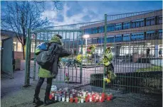  ?? FOTO: DPA ?? Vor der Käthe-Kollwitz-Gesamtschu­le zeigen Grablichte­r und Blumen die Anteilnahm­e der Menschen.