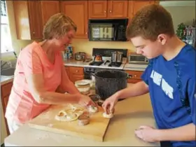  ?? PHOTOS BY DONNA ROVINS — DIGITAL FIRST MEDIA ?? Susan Good, left, and her son Christophe­r roll and cut fasnachts Saturday in Exeter. Once cut, the pastries were left to rise another four hours before being cooked.