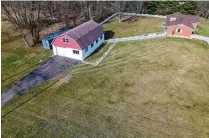  ?? CONTRIBUTE­D ?? The backyard is partially fenced with wood pickets, and the barn has a separate asphalt driveway.