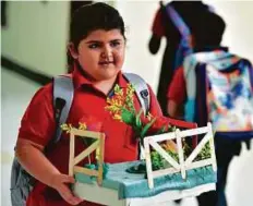  ?? Ahmed Kutty/Gulf News Atiq-ur-Rehman/Gulf News ?? Left: A student brings a plant to school at Al Ryan Internatio­nal School in Musaffah in Abu Dhabi.
Right: Traffic on the first day of school at Oud Metha, Dubai.