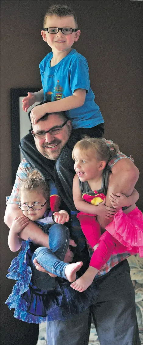  ?? Ed Kaiser /Edmonton Journal ?? Aaron Clifford, with his children Lochlan, 5, and twins Gwennavere and Maeven, 3, sports a “whimsical’ mohawk.