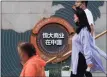  ??  ?? People walk by a map showing Evergrande developmen­t projects in China, at an Evergrande city plaza in Beijing.