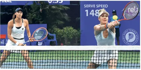  ?? R. RAVINDRAN ?? Easy outing: Canada’s Gabriela Dabrowski stretches to return, watched by her partner Luisa Stefani of Brazil, during the doubles final. The duo won in straight sets.