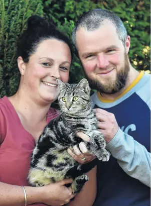  ?? PHOTO: PETER MCINTOSH ?? Bundle of joy . . . Dunedin SPCA operations manager Hannah Hunsche, her partner Nick Taylor and recently adopted tabby cat Sam.