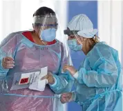  ?? DAVID SANTIAGO dsantiago@miamiheral­d.com ?? Healthcare workers talk at the COVID-19 drive-thru testing center at Miami-Dade County Auditorium in Miami on July 23.