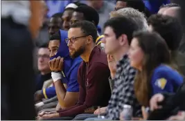  ?? GODOFREDO A. VÁSQUEZ — THE ASSOCIATED PRESS ?? Warriors guard Stephen Curry, second from left, watches from the bench during the second half against the Houston Rockets in San Francisco on Friday.