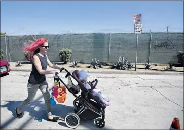  ?? Photograph­s by Brian van der Brug Los Angeles Times ?? A WOMAN walks past a former Metro bus yard on Sunset Avenue in Venice, one of five public properties that the agency says could be used to provide services or temporary housing for L.A. County’s homeless population.