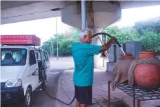  ??  ?? Natarajan refills a matka (pot) in Delhi. He has fitted a van with an 800 litre tank, a pump and a generator to run it.