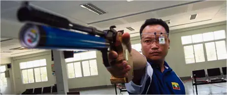  ??  ?? Target locked: Myanmar Olympic qualifier ye tun naung aims his air pistol at the target during practice at a shooting range in yangon on May 13. — AFP