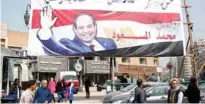  ?? - Reuters File ?? WOOING VOTERS: People walk by a poster of Egyptian President Abdel Fattah Al Sisi for the upcoming presidenti­al election, in Cairo, Egypt, on March 1, 2018.