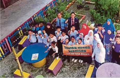  ??  ?? TENAGA pengajar dan murid PPKIBP yang mengusahak­an Taman Herba Warisan SK Teluk Menara, Manir.