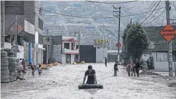  ?? FOTO: AGENCIA AP ?? Un hombre juega en una calle inundada usando un neumático de vehículo en Lima, Perú.