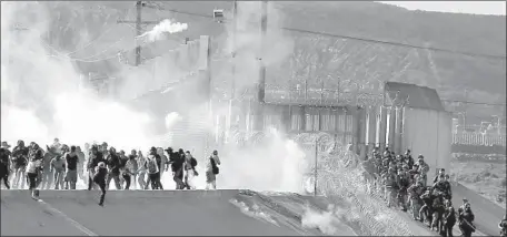  ?? David Guzman EPA/Shuttersto­ck ?? BORDER PATROL agents employ tear gas last month while blocking migrants near the San Ysidro Port of Entry. Kevin McAleenan, commission­er of U.S. Customs and Border Protection, was pressed by lawmakers Tuesday on the incident but said agents followed regulation­s.