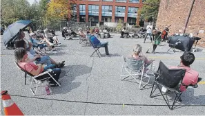  ?? CLIFFORD SKARSTEDT EXAMINER FILE PHOTO ?? People watch a performanc­e from “The 13th Sign Walks Into a Bar” at The Theatre On King parking lot on Sept. 26. New sweatshirt­s made by Nish Tees benefit the local theatre.