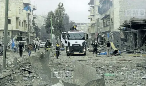  ?? EDLIB MEDIA CENTER VIA AP ?? Members of the Syrian civil defense known as the White Helmets, gathering at a street which was attacked by Russian airstrikes, in Maarat al-Nuaman town, southern Idlib province, Syria. Syrian government forces and allied militiamen are advancing on...