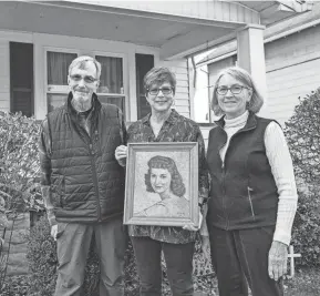  ?? ANDREW DOLPH/TIMES-REPORTER ?? Jeff Beaber, Sherie Reese and Patty Burson, from left, pose with a portrait of Betty Beaber, who died in 1965. The portrait was painted by a German prisoner of war During World War II. Betty Beaber’s husband, Richard Beaber, was a POW prison guard in Tennessee, where some prisoners were held during war time. He died Nov. 5 at 101 years old.