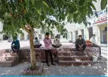  ?? —AFP ?? NEW DELHI: Migrants sit under the shade of a tree as they camp at a government school during a government-imposed nationwide lockdown on Friday.