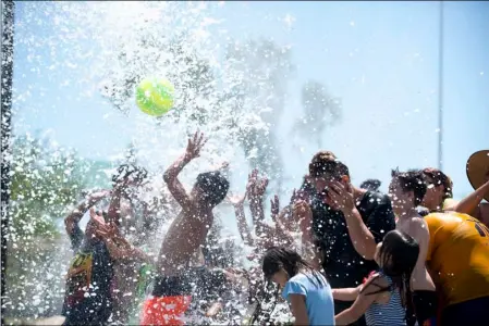  ?? VINCENT OSUNA PHOTO ?? Children and parents enjoy standing underneath a splash zone that drops water from above at Alyce A. Gereaux Park in Brawley on Saturday afternoon.