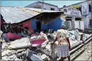  ?? DUPLES PLYMOUTH — THE ASSOCIATED PRESS ?? A woman stands in front of a destroyed home in the aftermath of an earthquake Aug. 14in Les Cayes, Haiti.