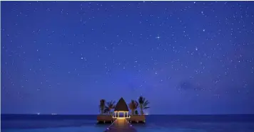  ??  ?? A canopy of stars dot the night sky above the arrival jetty at Kandolhu Island
