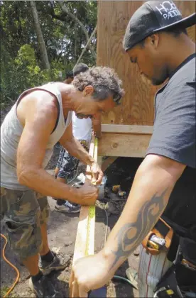  ??  ?? Rick Rutiz (left), executive director of Ma Ka Hana Ka ‘Ike, takes measuremen­ts on a job site in Hana in March of 2013. After 19 years of teaching hands-on building skills to students, Rutiz will retire from the nonprofit on July 1.