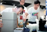  ?? YANG KEJIA / CHINA NEWS SERVICE ?? A Chinese team works on a cat food feeding machine at the finals in Beijing of a youth innovation contest this month. Two reports detailed the best cities for innovation.