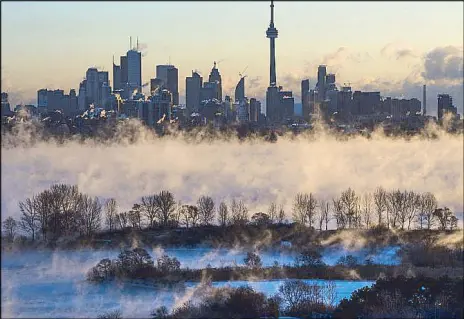  ??  ?? Mist rises from Lake Ontario in front of the Toronto skyline during an extreme cold weather Saturday. Canada has issued extreme cold warnings for provinces from Manitoba to New Brunswick.