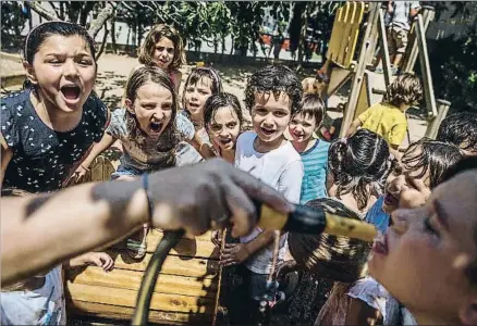  ?? DAVID AIROB ?? Alumnos de la escuela Pompeu Fabra de Barcelona se refrescan en el patio para combatir el calor