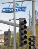  ?? Dan Watson/ The Signal ?? (Left) A Steinway Street resident rights his trash can after high winds knocked it over in Canyon Country on Wednesday. (Above) High winds blow a street sign ahead of the traffic lights being returned to service Wednesday at Soledad and Whites canyon roads.