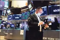  ?? Colin Ziemer / Associated Press ?? In this photo provided by the New York Stock Exchange, trader Edward Curran works on the floor, Thursday, Dec. 17, 2020.