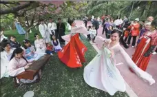  ?? WANG BIAO / FOR CHINA DAILY ?? College students wear traditiona­l hanfu clothing as they dance at a park in Fuyang, Anhui province, in April.