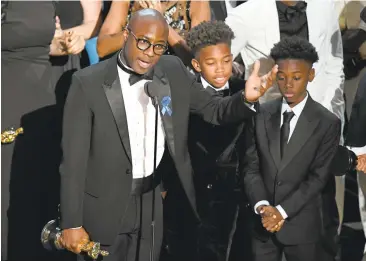  ?? KEVIN WINTER/GETTY IMAGES ?? Writer/director Barry Jenkins celebrates the best picture award for “Moonlight” with actors Jaden Piner and Alex R. Hibbert.