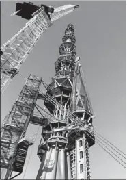  ??  ?? Workers prepare to raise the silver spire atop the One World Trade Center building in New York on May 10. The 408-foot spire will serve as a broadcast antenna.