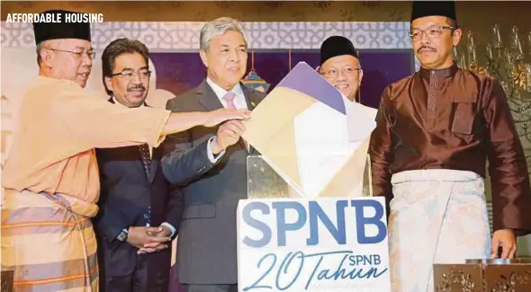  ?? PIC BY MOHD YUSNI ARIFFIN ?? Deputy Prime Minister Datuk Seri Dr Ahmad Zahid Hamidi launching SPNB’s Hari Raya Aidilfitri and 20th anniversar­y celebratio­ns at Menara Felda in Kuala Lumpur yesterday. With him are Second Finance Minister Datuk Seri Johari Abdul Ghani (second from...