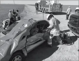  ?? LOANED PHOTO/SOMERTON/COCOPAH FIRE DEPARTMENT ?? SOMERTON/COCOPAH FIREFIGHTE­RS HAD TO USE a hydraulic power tool to pry the driver from his vehicle Wednesday afternoon following a two-car collision that left his door crumpled and unable to be opened. A pry bar also had to be used to get the passenger door dislodged from the telephone pole that was blocking it.