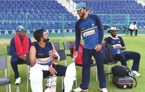  ?? Abdul Rahman/Gulf News ?? Sri Lankan captain Dinesh Chandimal (second right) and vice-captain, Lahiru Thirimanne (second from right) discuss during the team’s training session at Shaikh Zayed Stadium in Abu Dhabi yesterday.