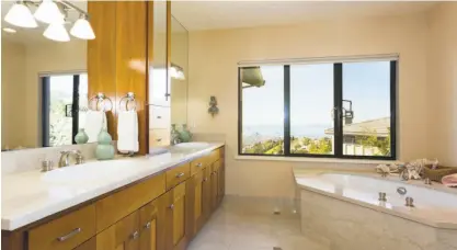  ?? Liz Rusby / Grubb Co. ?? A dramatic master bathroom boasts bay views, a raised soaking tub and dual vanities.