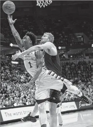  ?? ASSOCIATED PRESS ?? Geoffrey Groselle fouls Marquette guard Duane Wilson as he drives to the basket during the first half.