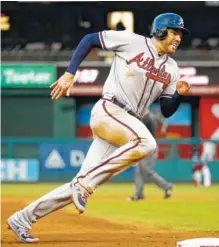  ??  ?? The Atlanta Braves’ Freddie Freeman rounds third base to score on Brian McCann’s single during the third inning on Tuesday.