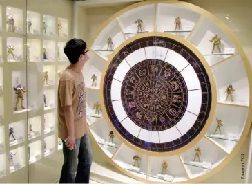  ??  ?? A young man looks at figurines from the popular Japanese anime Saint Seiya. Each character is designed based on the 12 zodiac signs. The anime is extremely popular among Chinese in their 30s