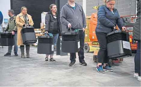  ?? ?? Poll workers line up with ballot boxes in preparatio­n to be counted.