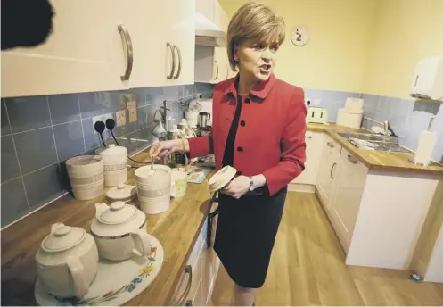  ?? PICTURE; PA ?? Nicola Sturgeon helps herself to a cup of tea amid a row over the tea used at Holyrood