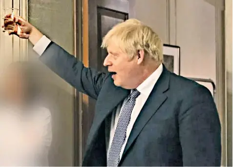  ?? ?? Boris Johnson appears to raise a glass of champagne at the leaving party for Lee Cain, his former communicat­ions chief, held during lockdown in November 2020