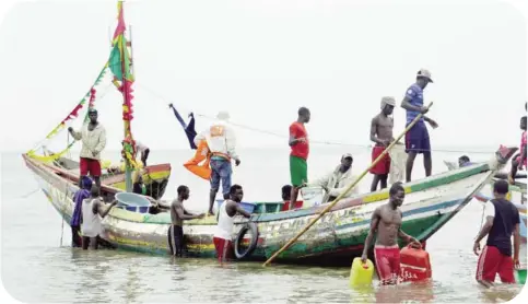  ?? — AFP ?? Fishermen stand on a boat in Conakry.