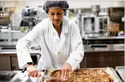  ?? NEW YORK TIMES ?? Joanna Graham, a food technologi­st, works in the kitchen lab in the Natick Soldier Research, Developmen­t &amp; Engineerin­g Center in Massachuse­tts. The latest entree to join the roster of fifield rations is a Sicilian-style slice that stays fresh for years.