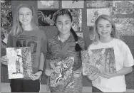  ?? Janelle Jessen/Siloam Sunday ?? Seventh-grade students Lilly Cole, Hannah Colon and Kami Hulbert held the collages they created of endangered species in Arkansas for the 8th annual Arkansas Endangered Species Day Contest. Art and science teachers collaborat­ed on the project to study...