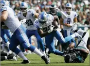  ?? MICHAEL PEREZ — THE ASSOCIATED PRESS ?? The Lions’ Kerryon Johnson (33) rushes over the Philadelph­ia Eagles’ Brandon Graham (55) during the first half of an NFL football game Sunday in Philadelph­ia.