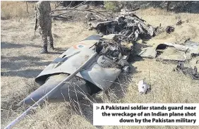  ??  ?? &gt; A Pakistani soldier stands guard near the wreckage of an Indian plane shot down by the Pakistan military